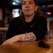Une femme assise au comptoir d'un bar &agrave; Montr&eacute;al.
