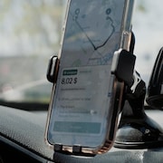 Un t&eacute;l&eacute;phone cellulaire fix&eacute; au tableau de bord d&rsquo;une voiture affiche un itin&eacute;raire de navigation pendant une livraison.