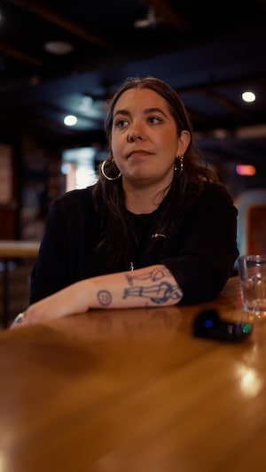 Une femme assise au comptoir d'un bar à Montréal.