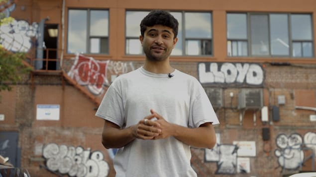 Le stagiaire Haroun Aramis devant un mur de brique.