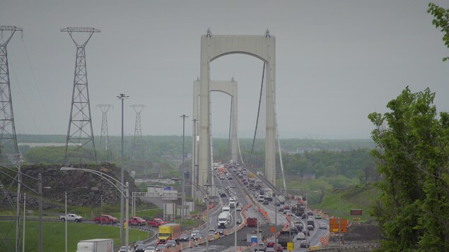 Le pont de Québec avec des cônes de construction et du trafic.