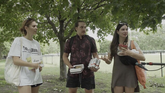 Trois personnes dans un parc, avec des canettes de « seltzers » à la main.